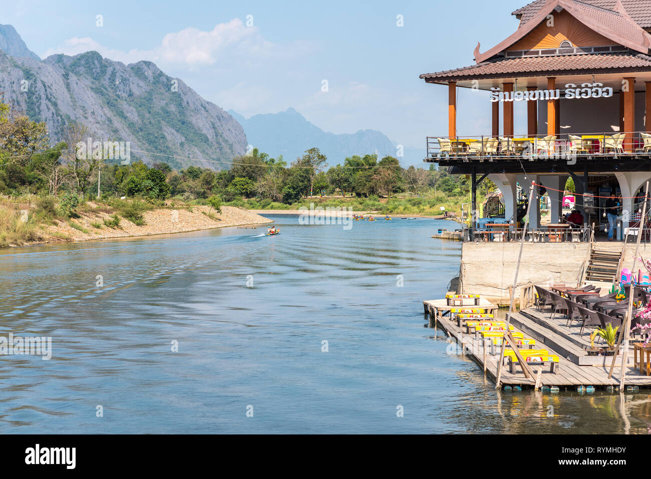 Vang Vieng, Laos - Dezember 28, 2018: ein Restaurant am Fluss, den Nam Song Fluss- und Berglandschaft im Hintergrund. Stockfoto