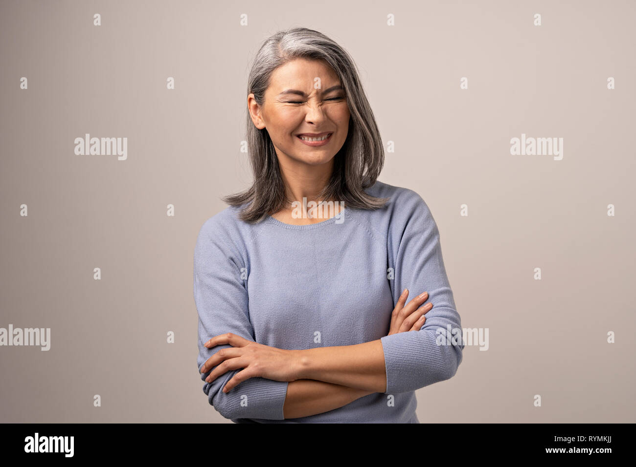 Lächelnd Asiatischen ältere Frau mit verschränkten Armen Stockfoto