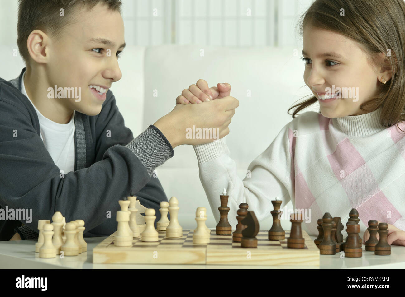 Porträt der Jungen und Mädchen Schach spielen Stockfoto