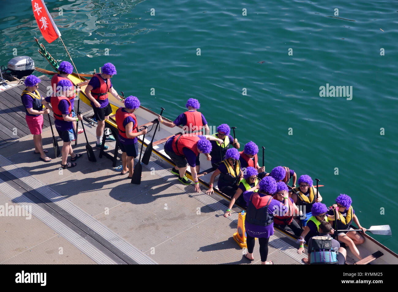 Eine Crew in Lila Perücken Bereit für die Dragon Rennen im Albert Dock, St Helier, Jersey, Channel Isles, UK. Stockfoto