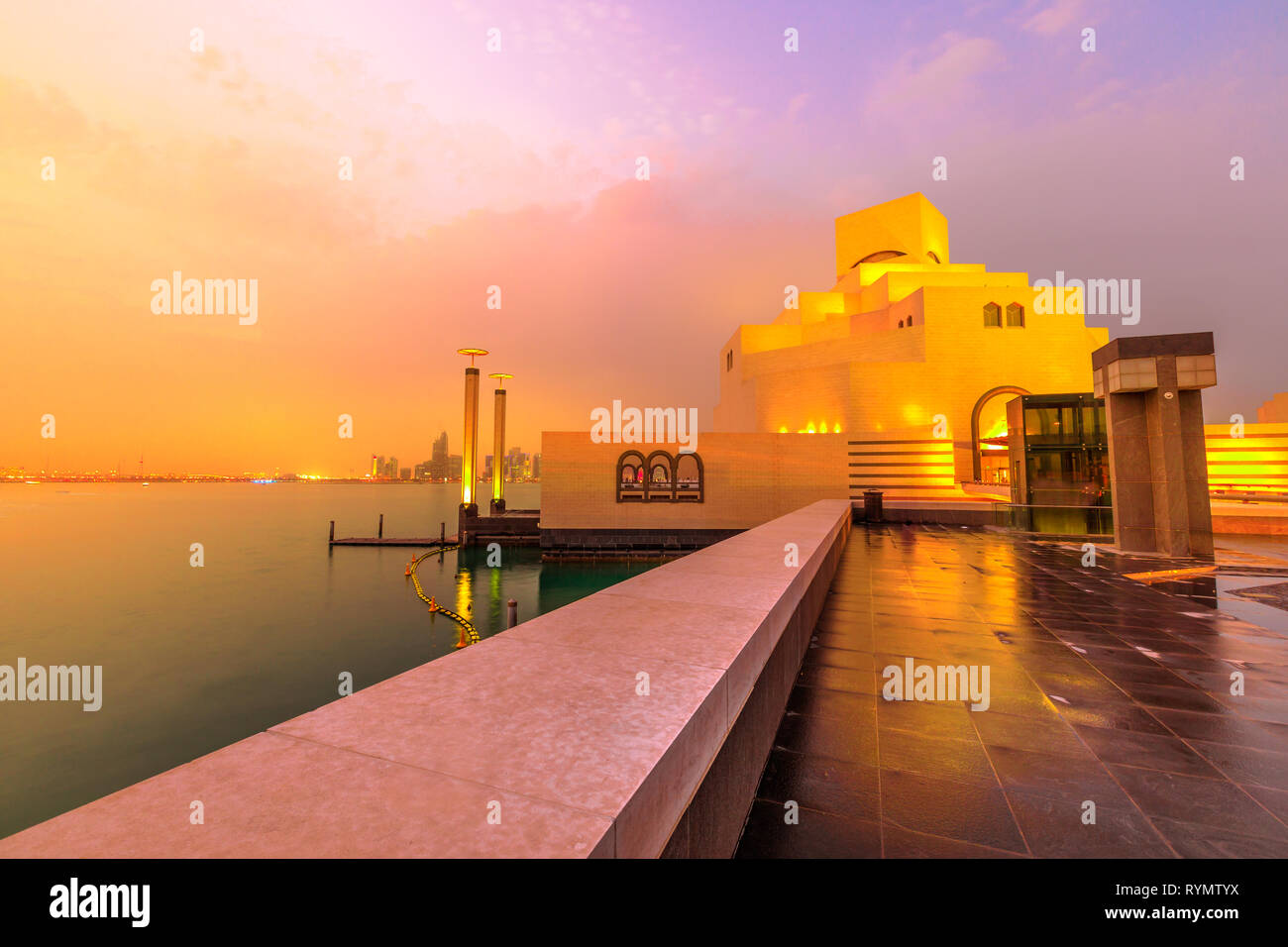Meer und West Bay von Doha Skyline entlang der Corniche in der katarischen Hauptstadt mit Dhow-hafen Beleuchtung an der blauen Stunde. Doha in Katar. Naher Osten, Arabische Stockfoto