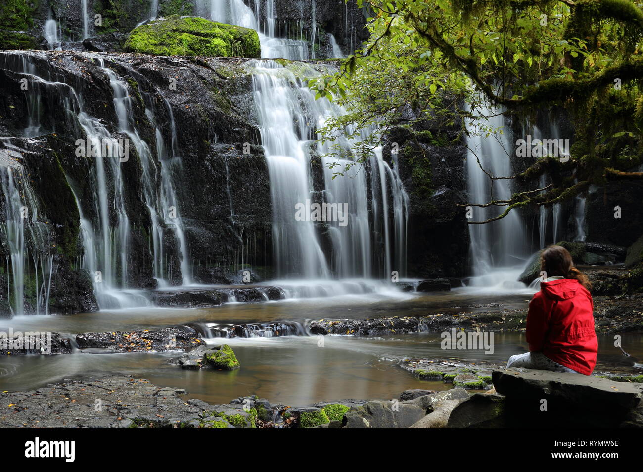 Purakaunui Falls, die Catlins, Neuseeland, mit Mädchen in der roten Jacke Stockfoto