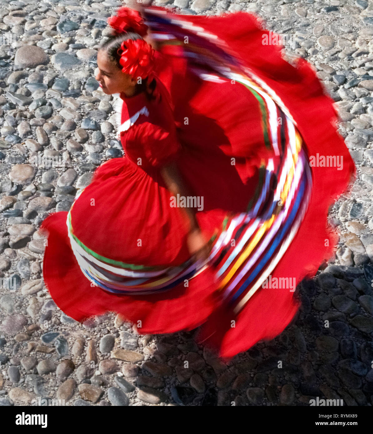 Eine Ansicht zeigt die farbenfrohe Tracht eines twirling weiblichen folkloristische Tänzer, unterhält die Touristen in Puerto Vallarta an der Pazifikküste von Mexiko, Nordamerika. Stockfoto