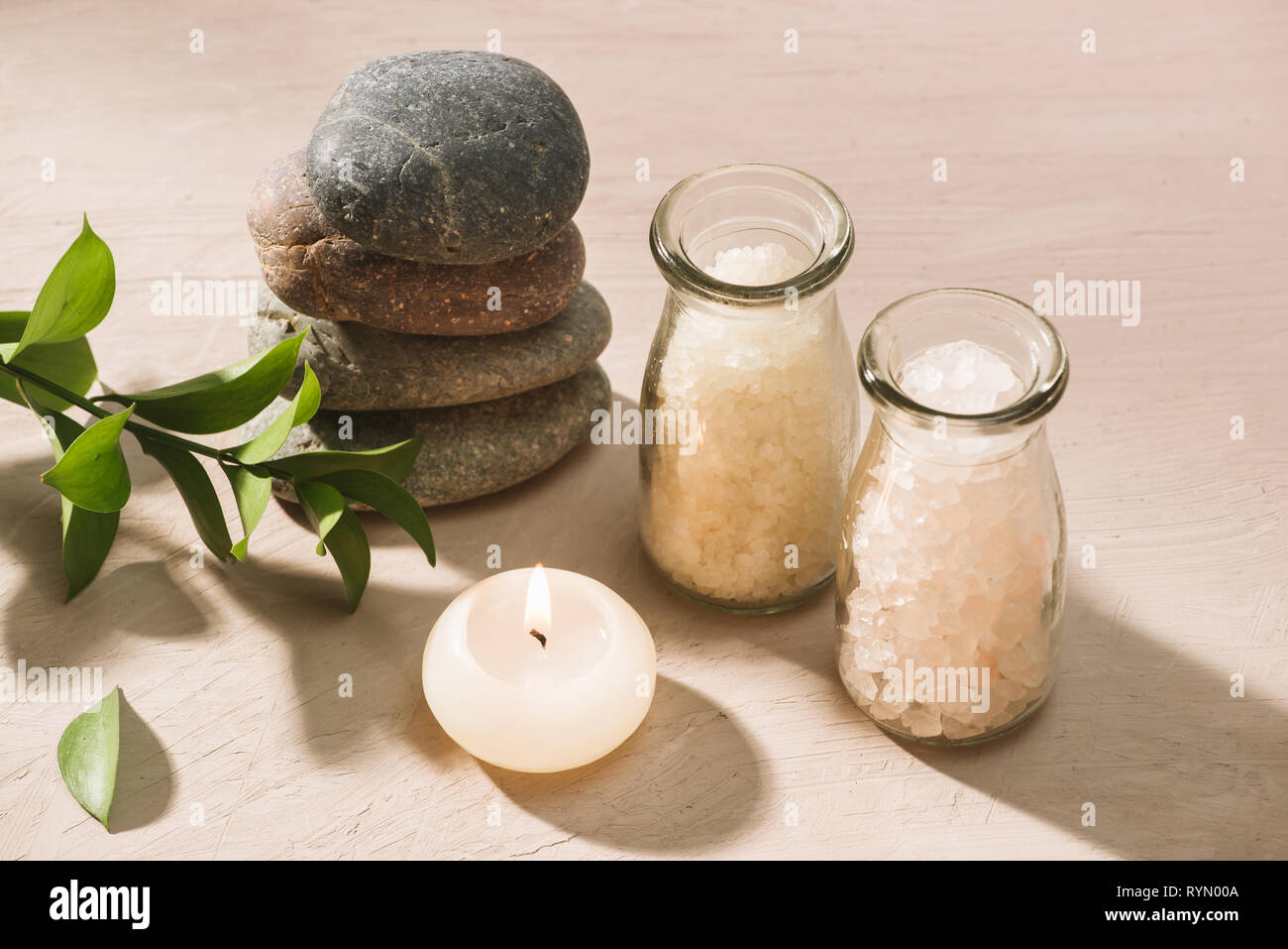 Brennende Kerze in Wasser. Spa Einstellung mit Salz und Kieselsteinen auf  hölzernen Hintergrund Stockfotografie - Alamy