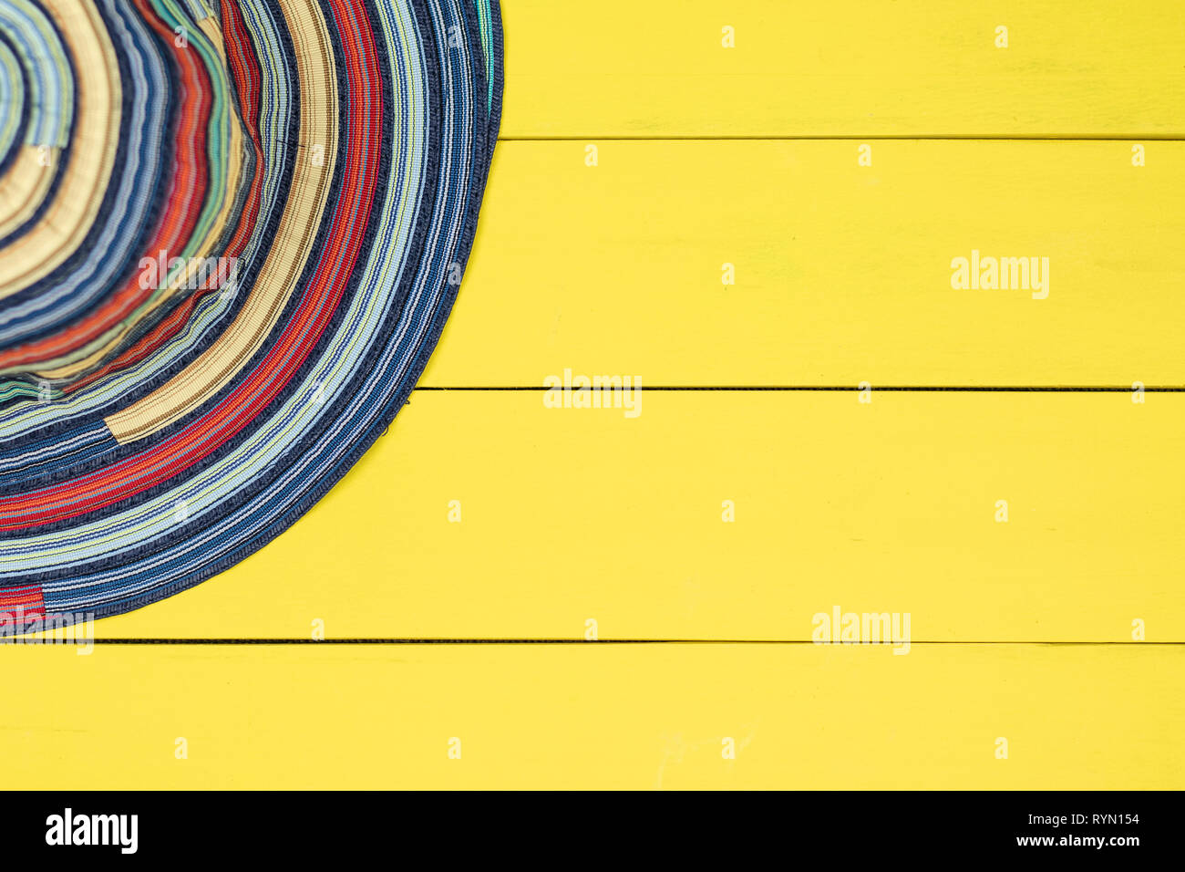 Mehrfarbige tuch Hut auf gelb Holz- Hintergrund. Stockfoto