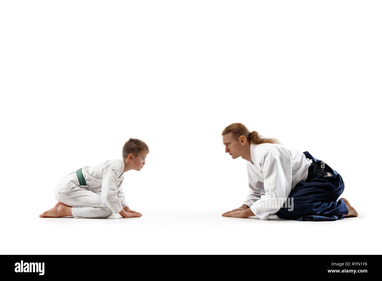 Mann und jugendlich Junge an Aikido Training in Martial Arts School. Gesunder Lebensstil und Sport Konzept. Fightrers in weißen Kimono auf weißem Hintergrund. Karate Männer mit konzentrierten Gesichter in Uniform Grüße. Stockfoto