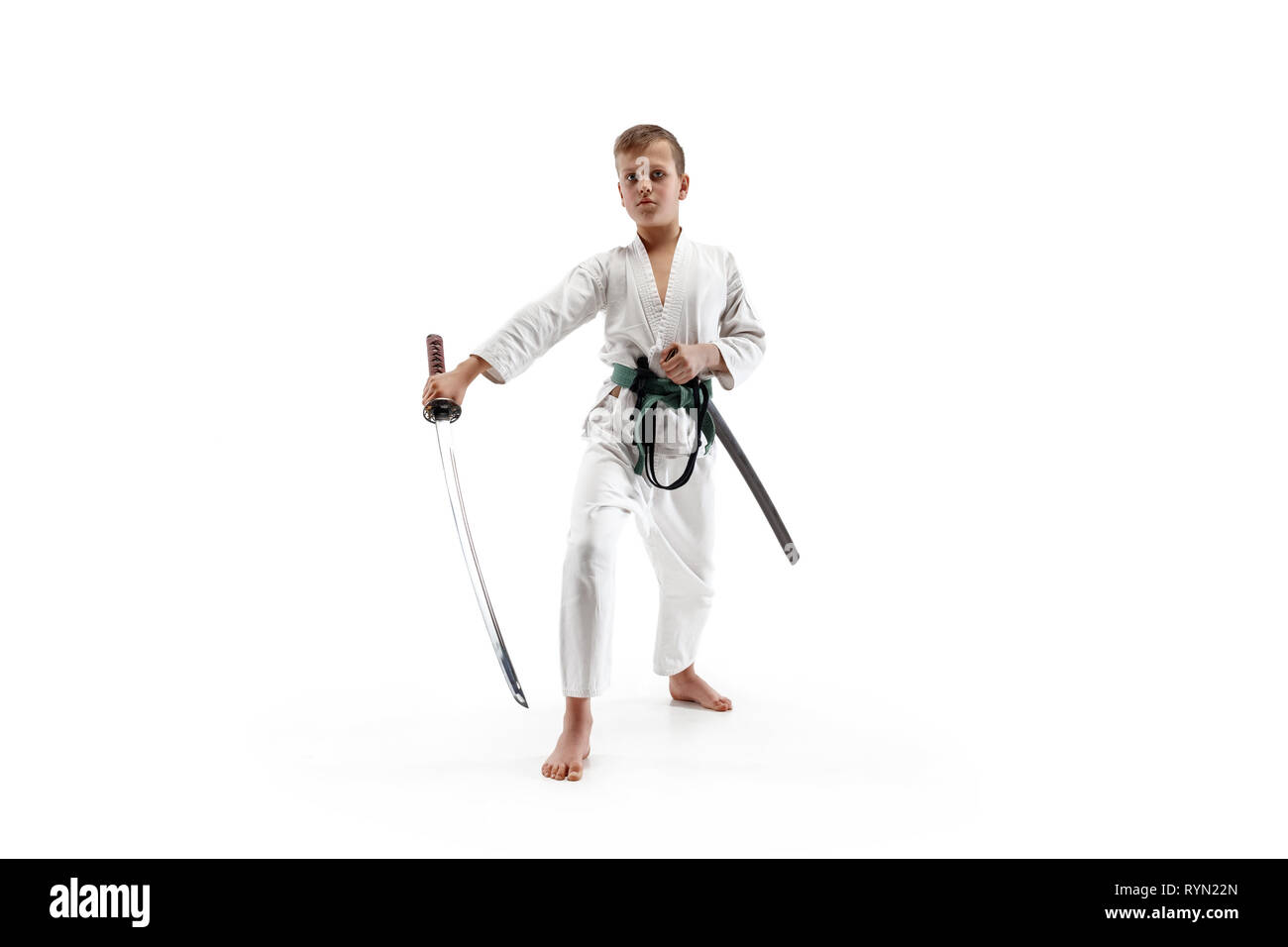 Jugendlich junge Kämpfe an Aikido Training in Martial Arts School. Gesunder Lebensstil und Sport Konzept. Fightrer in weißen Kimono auf weißem Hintergrund. Karate Mann mit Konzentriertem Gesicht in Uniform. Stockfoto