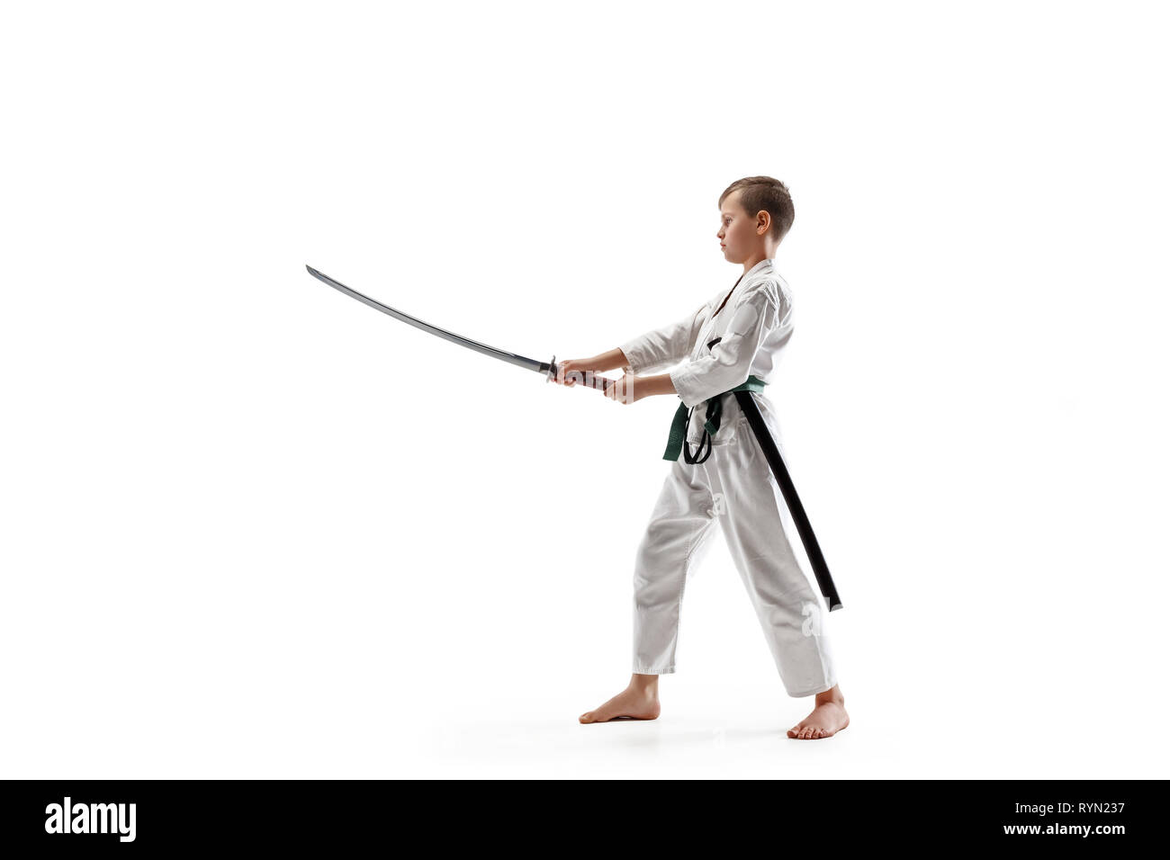 Jugendlich junge Kämpfe an Aikido Training in Martial Arts School. Gesunder Lebensstil und Sport Konzept. Fightrer in weißen Kimono auf weißem Hintergrund. Karate Mann mit Konzentriertem Gesicht in Uniform. Stockfoto