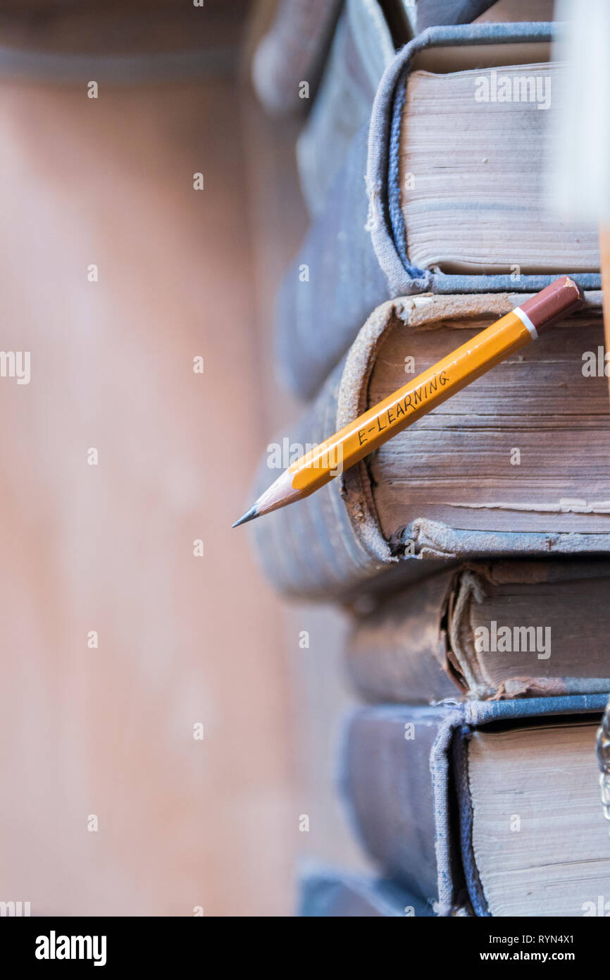 Online Bildung, e-learning Konzept. Inschrift auf einem Bleistift und Vintage Books. Stockfoto