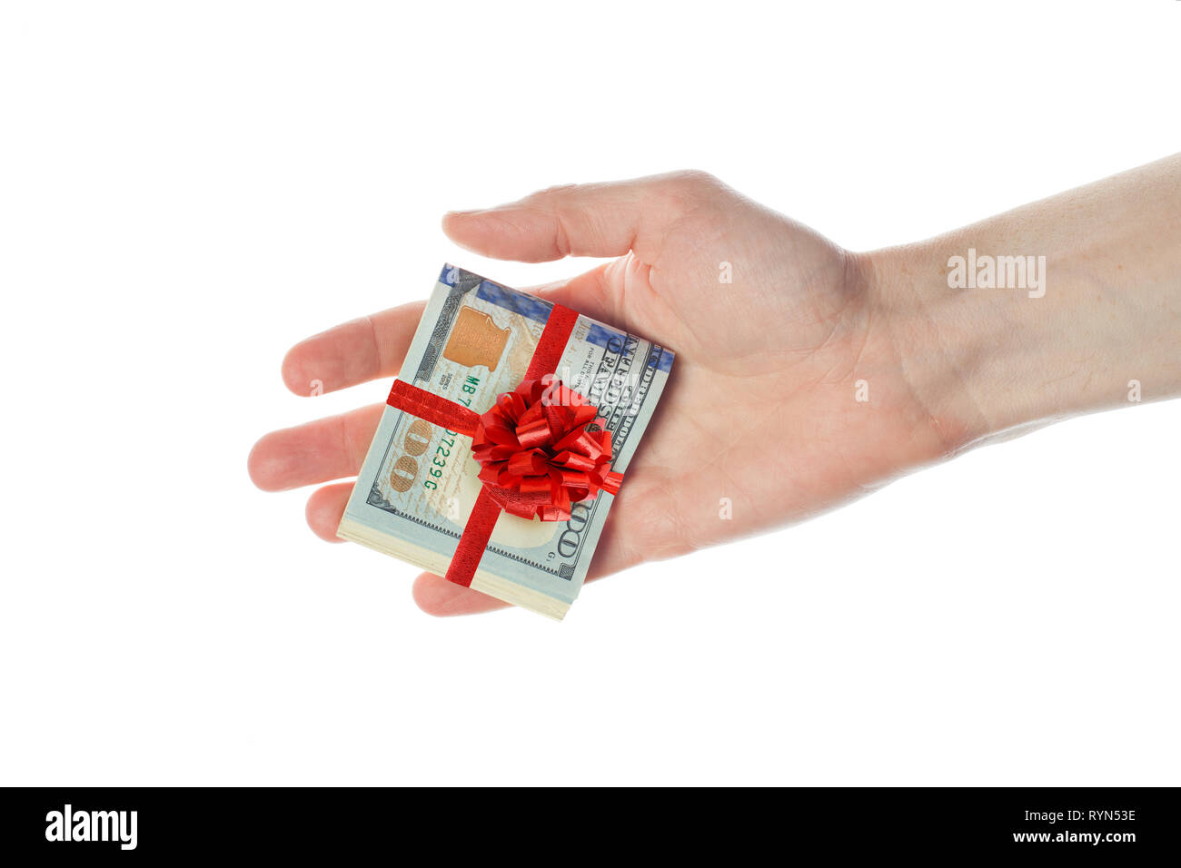 US-Dollar Bargeld mit roter Schleife in männlicher Hand auf weißem Hintergrund. Geschenk des Amerikanischen Dollar 100 Banknoten Stockfoto