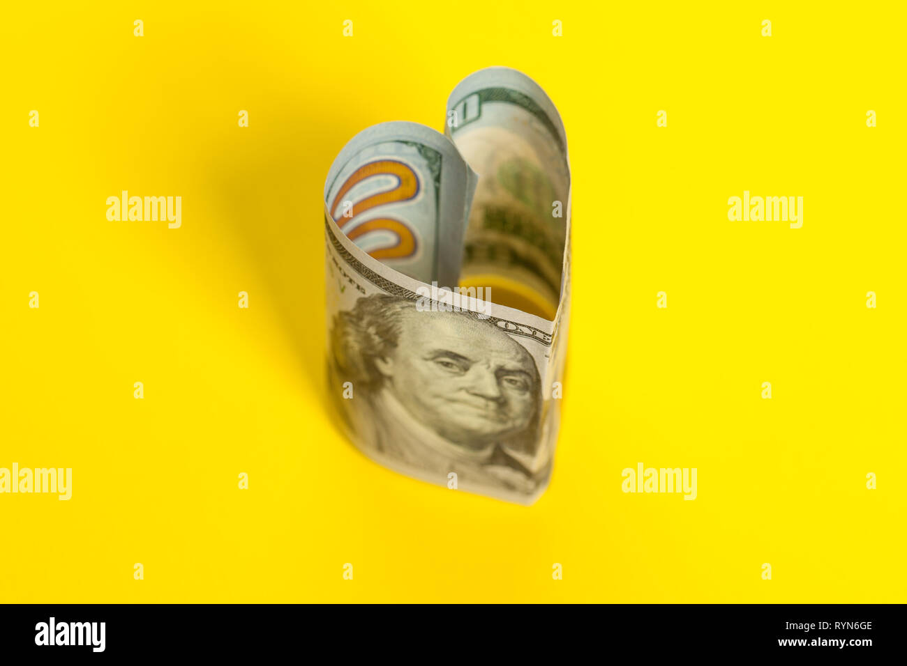 Herzen von 100 US-Dollar Hinweis auf gelbem Hintergrund Stockfoto