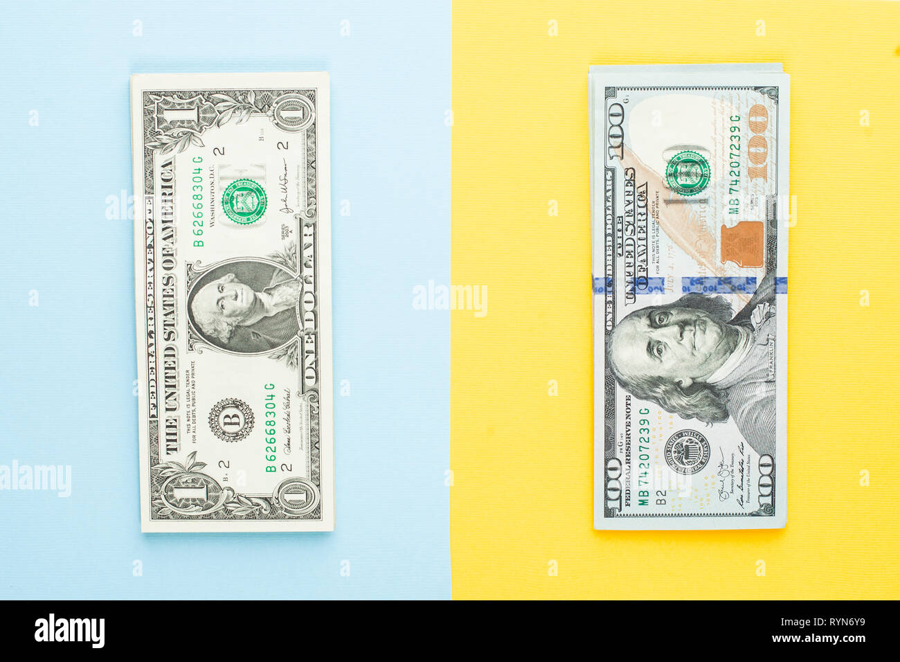 Kommerzielle Geldanlage gewinn Konzept. 1 US-Dollar und 100 Dollar. Haufen von 1 US-Dollar Banknote und Hundert us-Dollar Scheine auf Blau und Gelb b Stockfoto