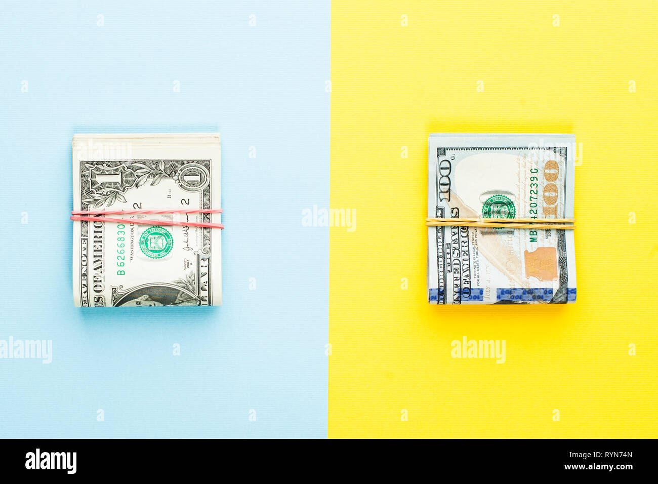 Haufen von 1 US-Dollar Banknote und moderne Hundert us-Dollar Scheine auf blauen und gelben Hintergrund. Kommerzielle Geldanlage gewinn Konzept Stockfoto