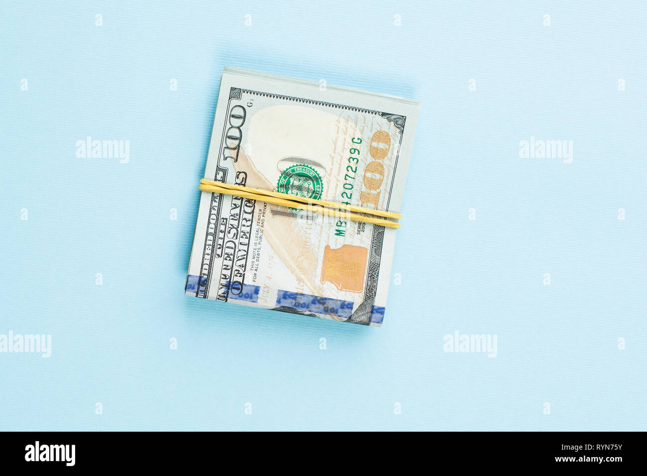 100 US-Dollar Geld Bargeld bei der blauen Tabelle Hintergrund Stockfoto