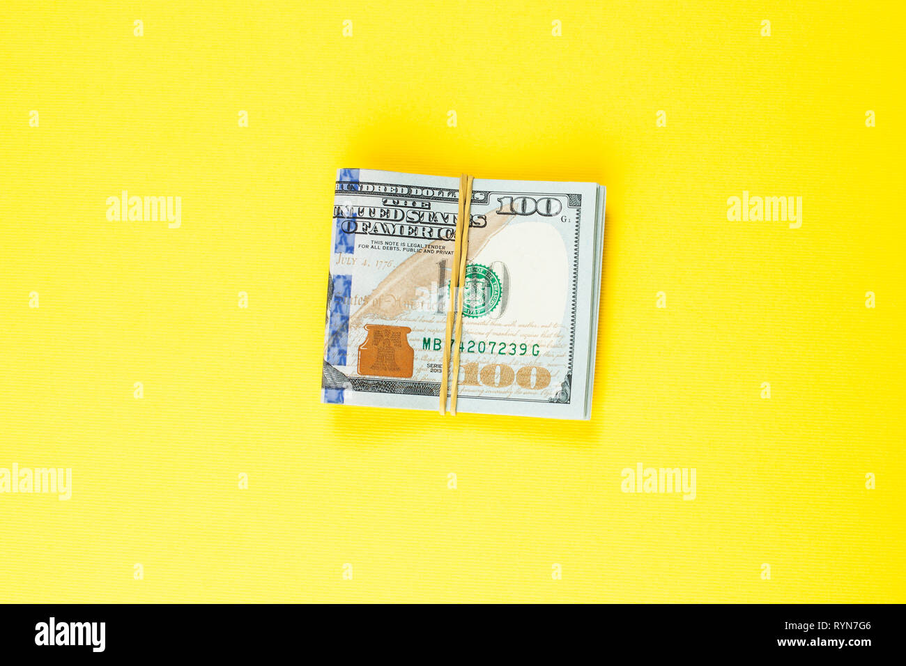 US Dollar Geld cash auf gelben Hintergrund. 100 amerikanische Dollar Banknote Stockfoto
