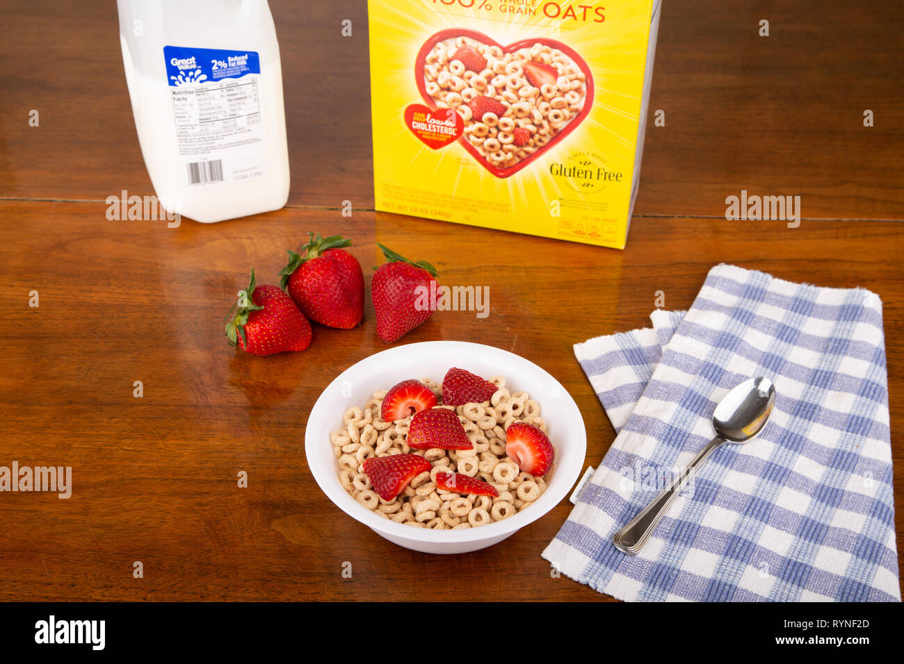 Ein Herz - gesunde, fettarme, niedrigen Cholesterin Frühstück mit Cheerios, in Scheiben geschnittene Erdbeeren und 2 Prozent Milch Stockfoto