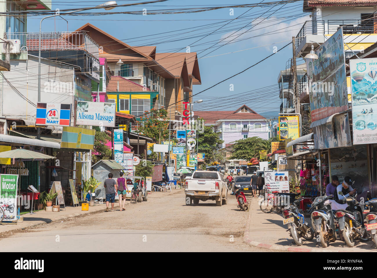 Einer der zentralen Straßen der Stadt Vang Vieng mit seinen chaotischen Architektur und die Fülle der Zeichen Platten unterschiedlicher Arten von Tourismus unternehmen. Stockfoto