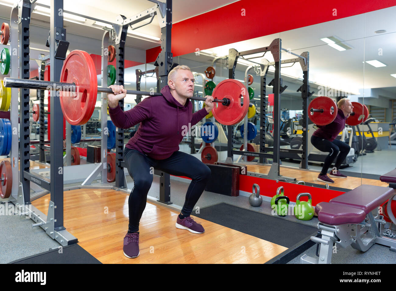Junger Mann Heben schwerer Gewichte während eines Training Session. Mann Training mit Langhantel Stockfoto