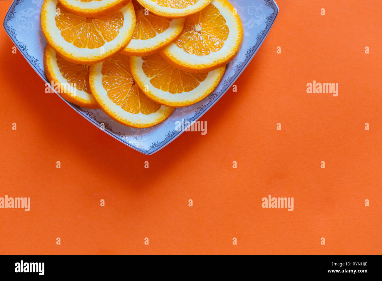 In Scheiben geschnittene Orangen auf einem orangefarbenen Hintergrund Stockfoto