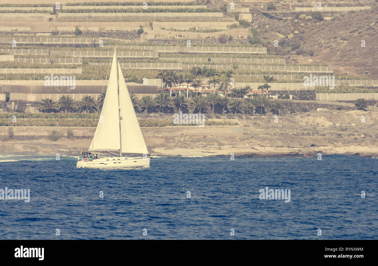 Einsam Segel yacht siling Vergangenheit terrasse Felder. Stockfoto