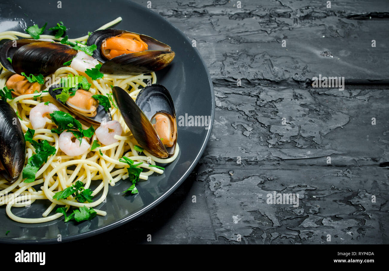 Mediterrane Speisen. Meeresfrüchte Spaghetti mit Venusmuscheln. Auf einem schwarzen Hintergrund im Landhausstil. Stockfoto
