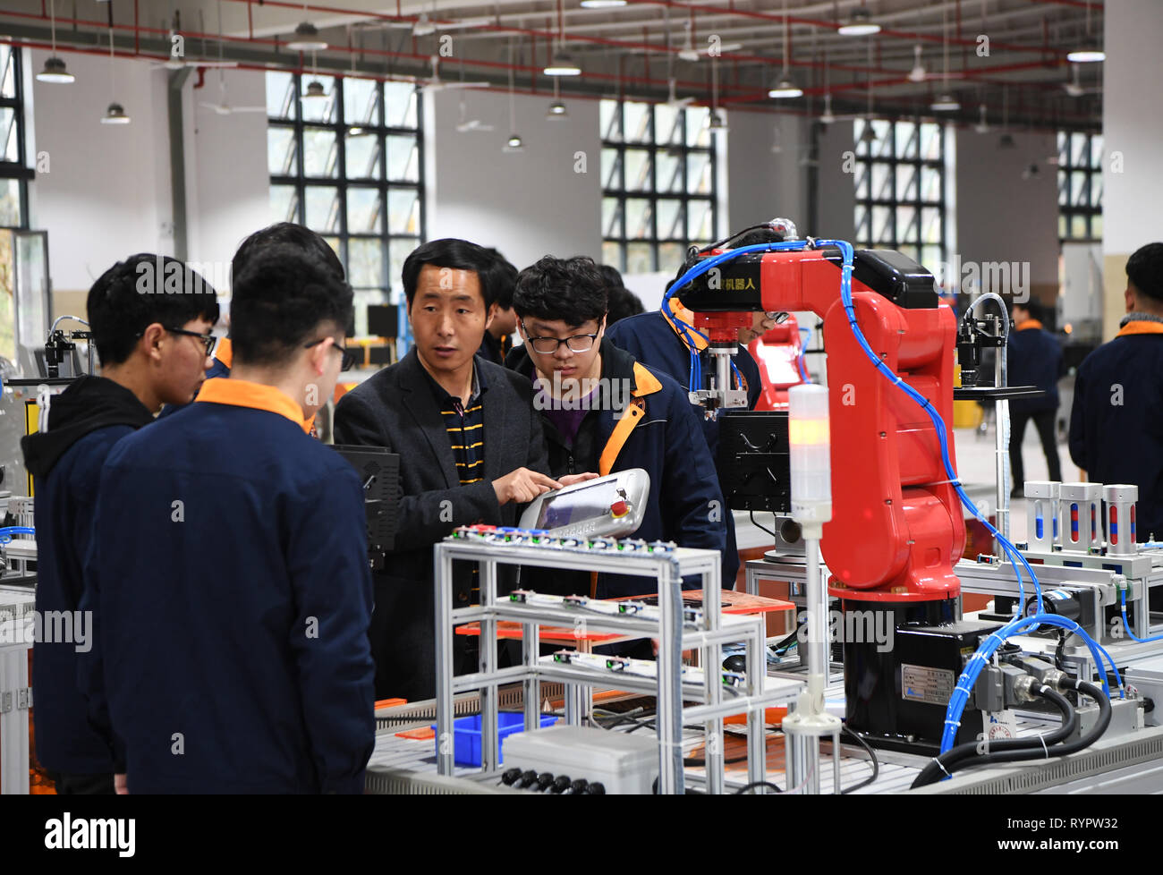 Chongqing, China. 14 Mär, 2019. Eine Lehrerin gibt einen Vortrag über Industrieroboter in der beruflichen Bildung Schule im yongchuan Bezirk von Chongqing, im Südwesten von China, 14. März 2019. Die lokalen Behörden bei der Verbesserung der beruflichen Bildung auf die Bedürfnisse des Arbeitsmarktes in den letzten Jahren gerecht zu werden. Credit: Wang Quanchao/Xinhua/Alamy leben Nachrichten Stockfoto