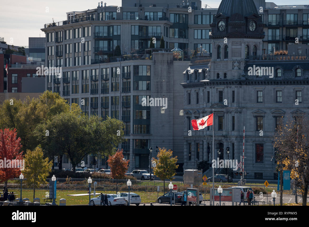 MONTREAL, KANADA - 4. NOVEMBER 2018: Die kanadische Flagge Verzicht auf der Uferpromenade von Old Montreal, mit Fußgängern vorbei. Die Altstadt von Montreal oder Vieux Montr Stockfoto
