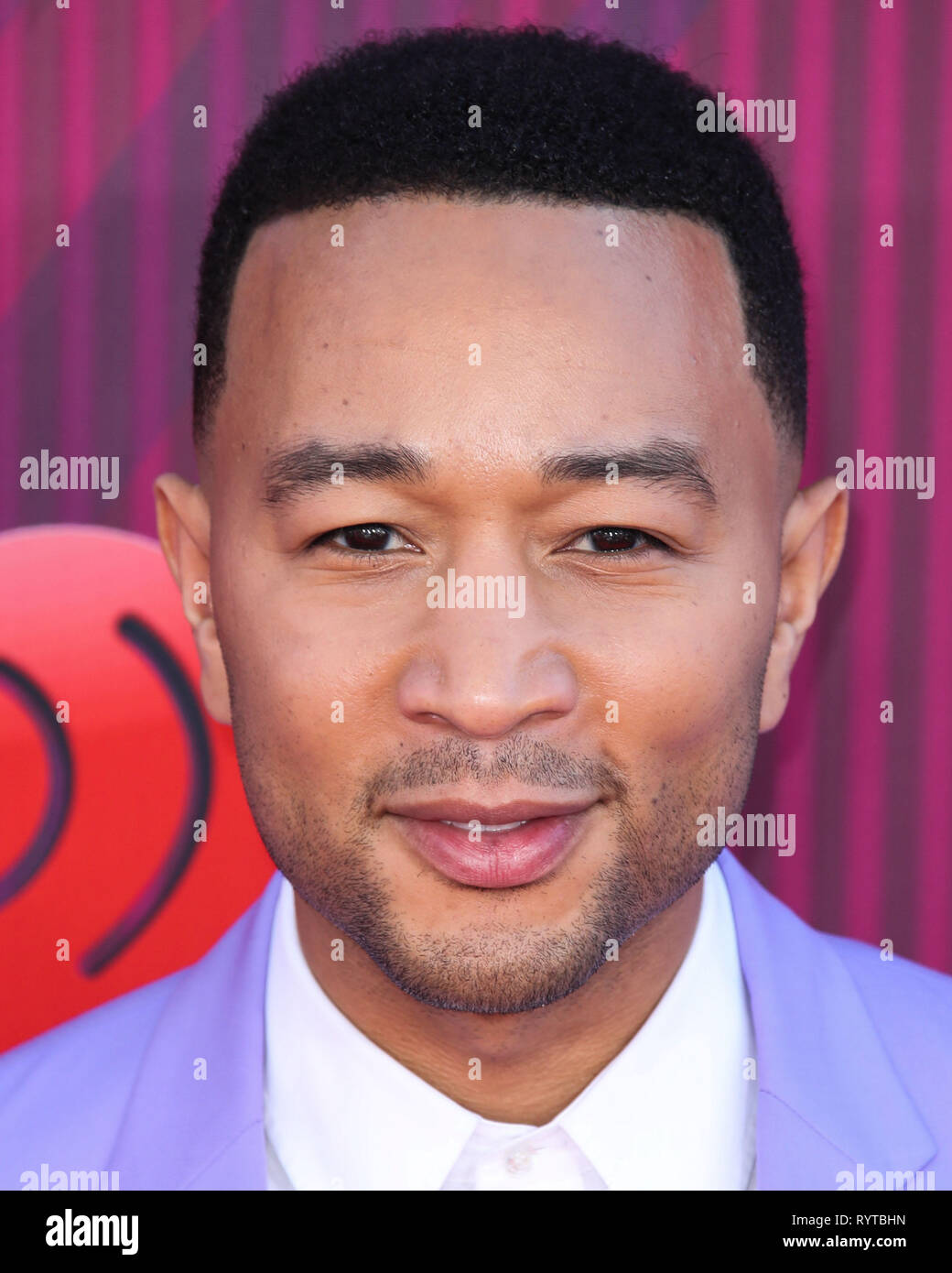 LOS ANGELES, Ca, USA - 14. März: Sänger John Legend Tragen eines Paul Smith Anzug und Celine Stiefel kommt an der 2019 iHeartRadio Music Awards bei Microsoft Theater in L.A. statt Live am 14. März 2019 in Los Angeles, Kalifornien, USA. (Foto von Xavier Collin/Image Press Agency) Stockfoto