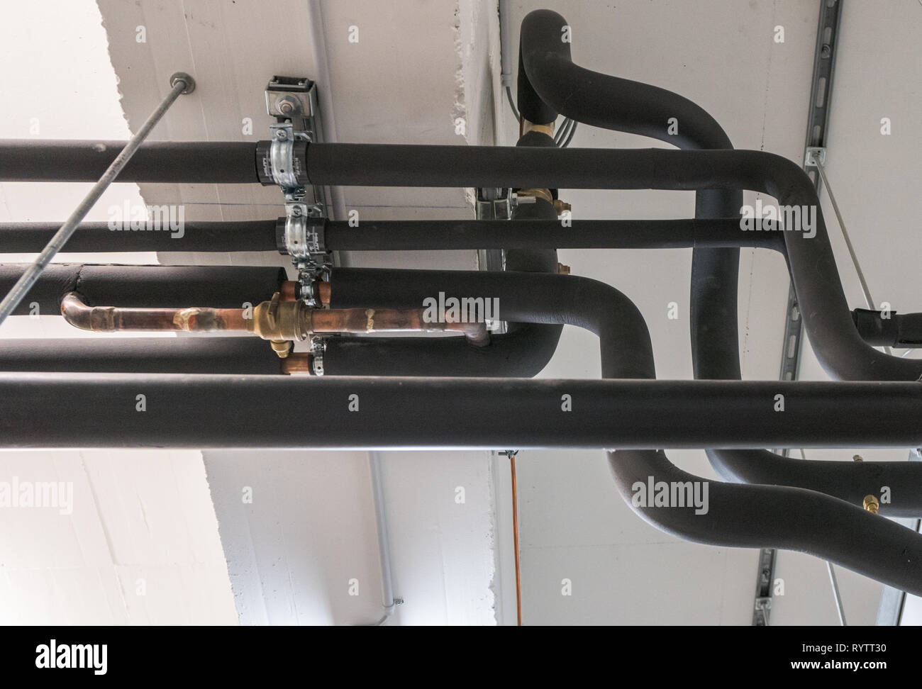 Metall und Kunststoff Rohr-system auf der Kellerdecke eines  Mehrfamilienhauses mit Wasser- und Heizungsrohre Stockfotografie - Alamy