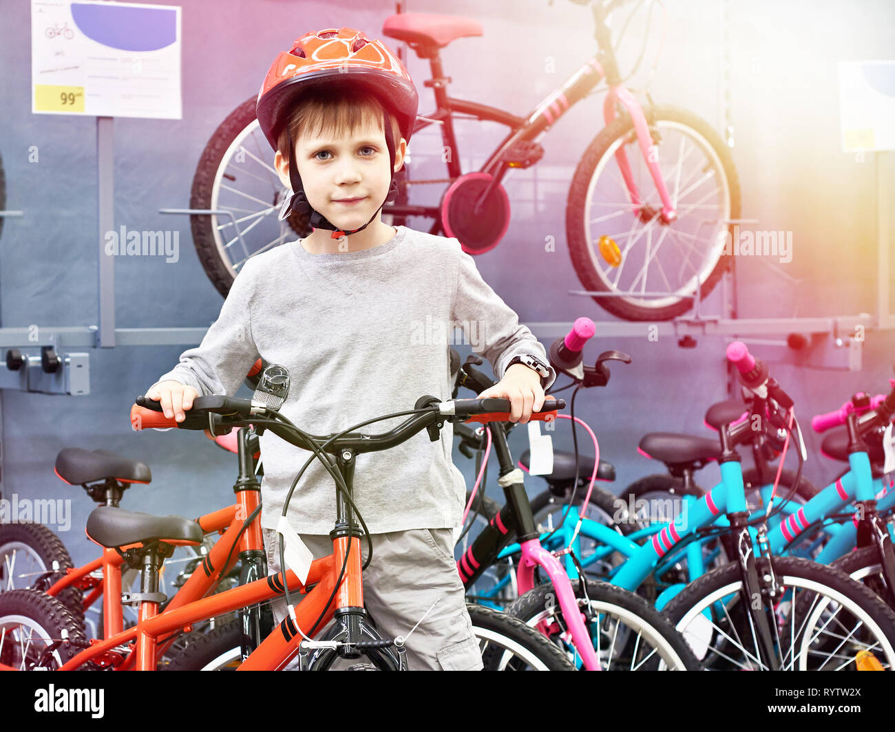 Junge in Helm wählt mit dem Fahrrad in einen Sport Supermarkt Stockfoto