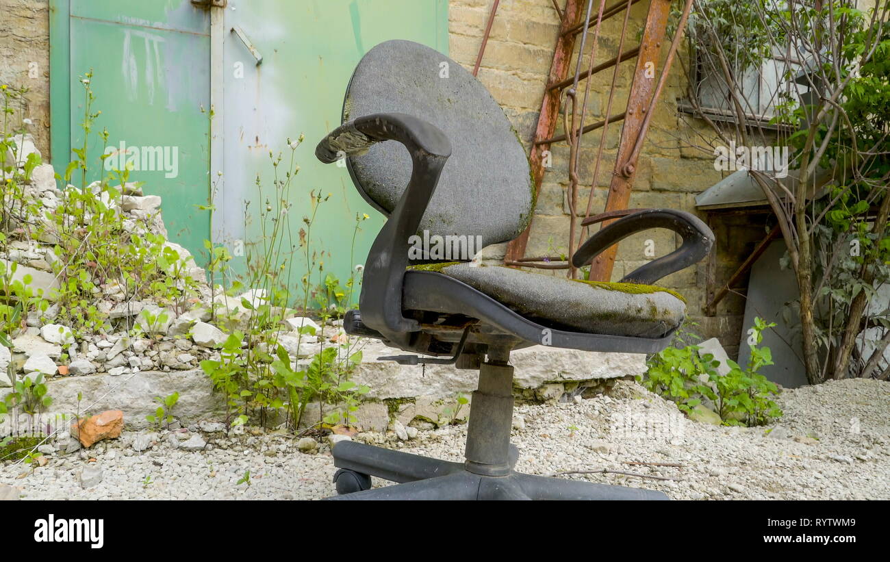 Eine alte Drehstuhl auf der Vorderseite des Gebäudes mit einer Leiter und die Reben von Pflanzen auf es Stockfoto