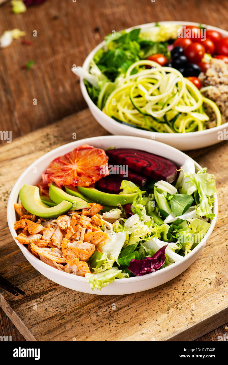 Nahaufnahme von zwei verschiedenen Buddha Schüssel Salat, mit Salat, cornsalad, Quinoa, Zucchini Spaghetti, Blaubeeren, Zuckerrüben, Huhn oder Cherry Tomaten, Stockfoto