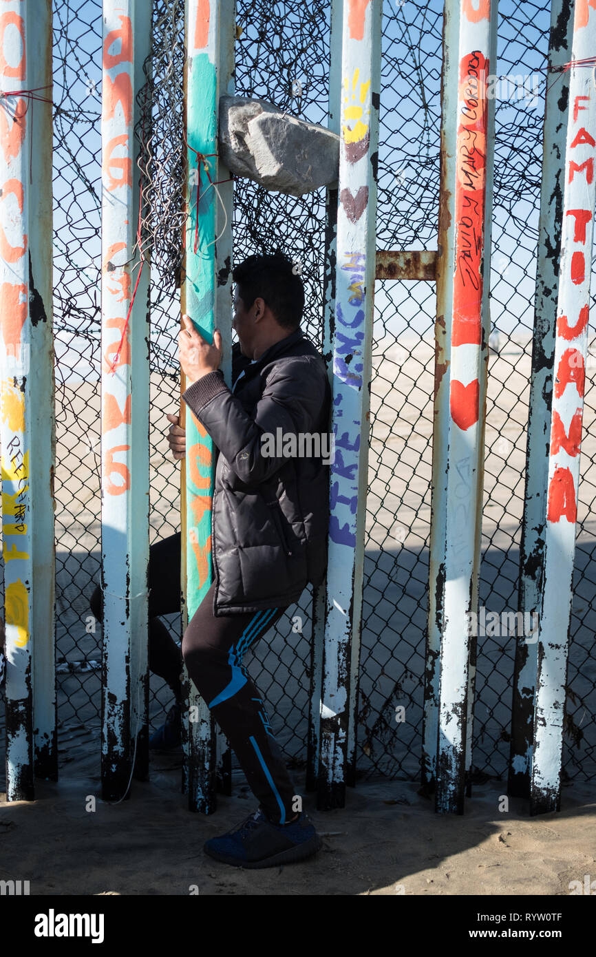 Ein junger Mann wird gesehen, rutscht durch die Vereinigten Staaten und Mexiko Grenze in Bemühungen um Asyl in den Vereinigten Staaten zu suchen. Im Februar 2019, rund 76.000 floh aus der südlichen Grenze in die Vereinigten Staaten, um ein besseres Leben zu finden. Stockfoto