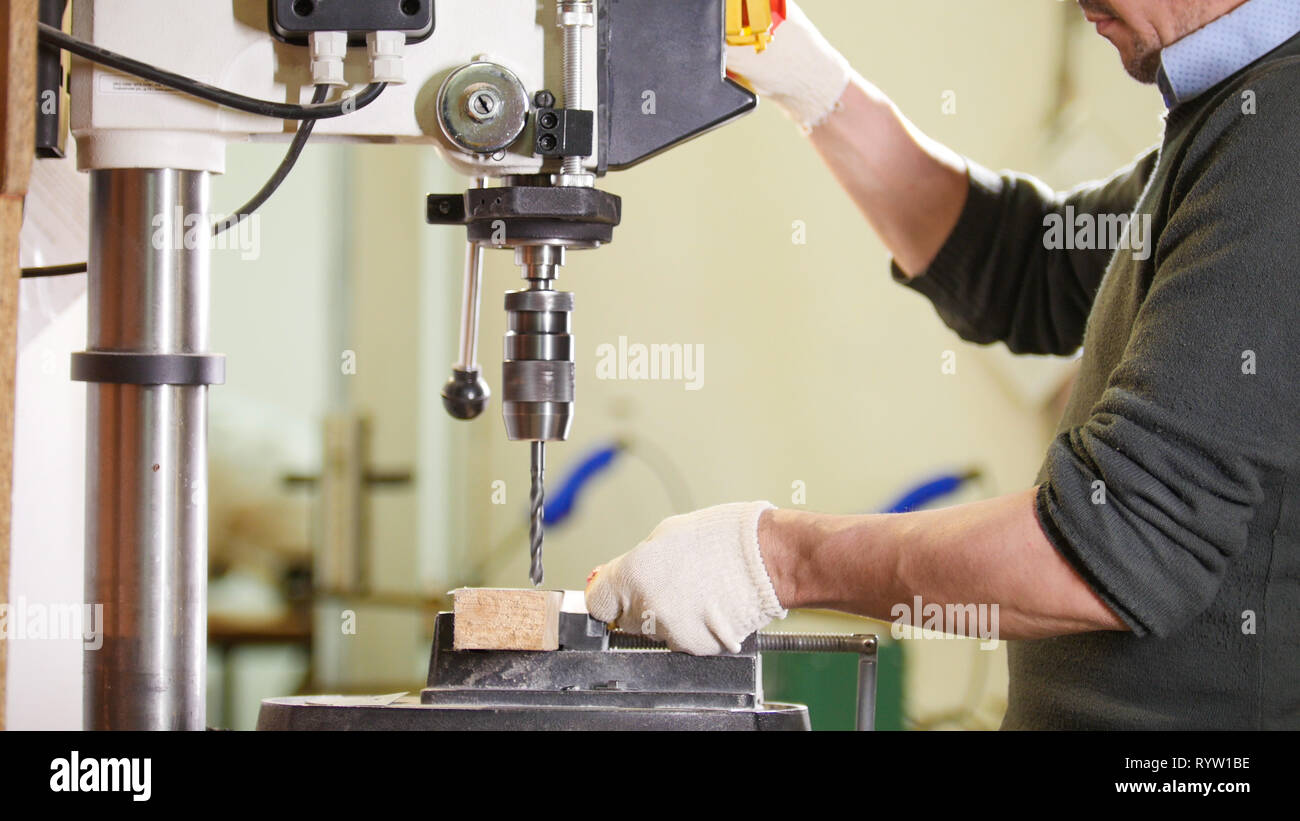 Industrielle Bohrmaschine - Arbeitnehmer macht Löcher in Metallen Stockfoto