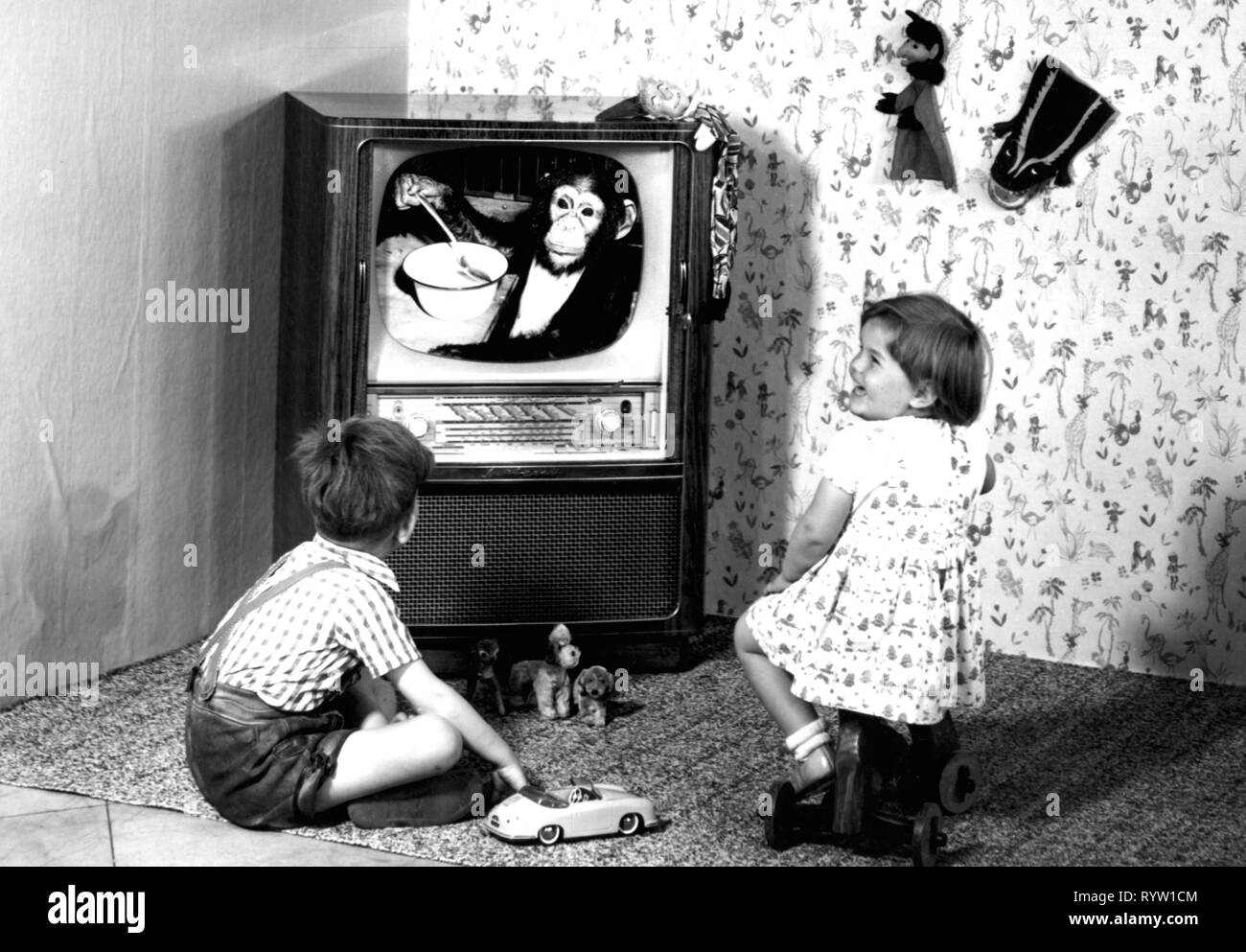 Rundfunk, Fernsehen, zwei Kinder vor einem Fernseher Graetz Kurfuerst F 371, Deutschland, 1960, Spielzeug, Spielzeug, Spielzeugautos, Spielzeug, Autos, Fernsehsendungen, Tier Telecast, Affen, affen, tiere, tier, Menschen, Wohnzimmer, Salon, Wohnzimmer, Wohn- Zimmer, Wohnzimmer, Zimmer, Wohnzimmer, Zimmer, Beruf, Technik, Industrie, Industrie, Elektronik, Unterhaltungselektronik, Haushaltsgeräte, Home Entertainment, Telekommunikation, Telekommunikation, Telecom, Deutschland, 20. Jahrhundert, 1960er Jahre, Kinder, Kind, Kinder, Kind, Fernseher,, Additional-Rights - Clearance-Info - Not-Available Stockfoto