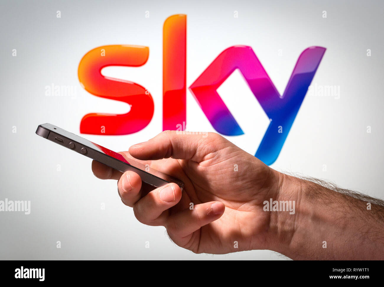 Ein Mann mit einem Handy vor Himmel Zeichen logo Stockfoto