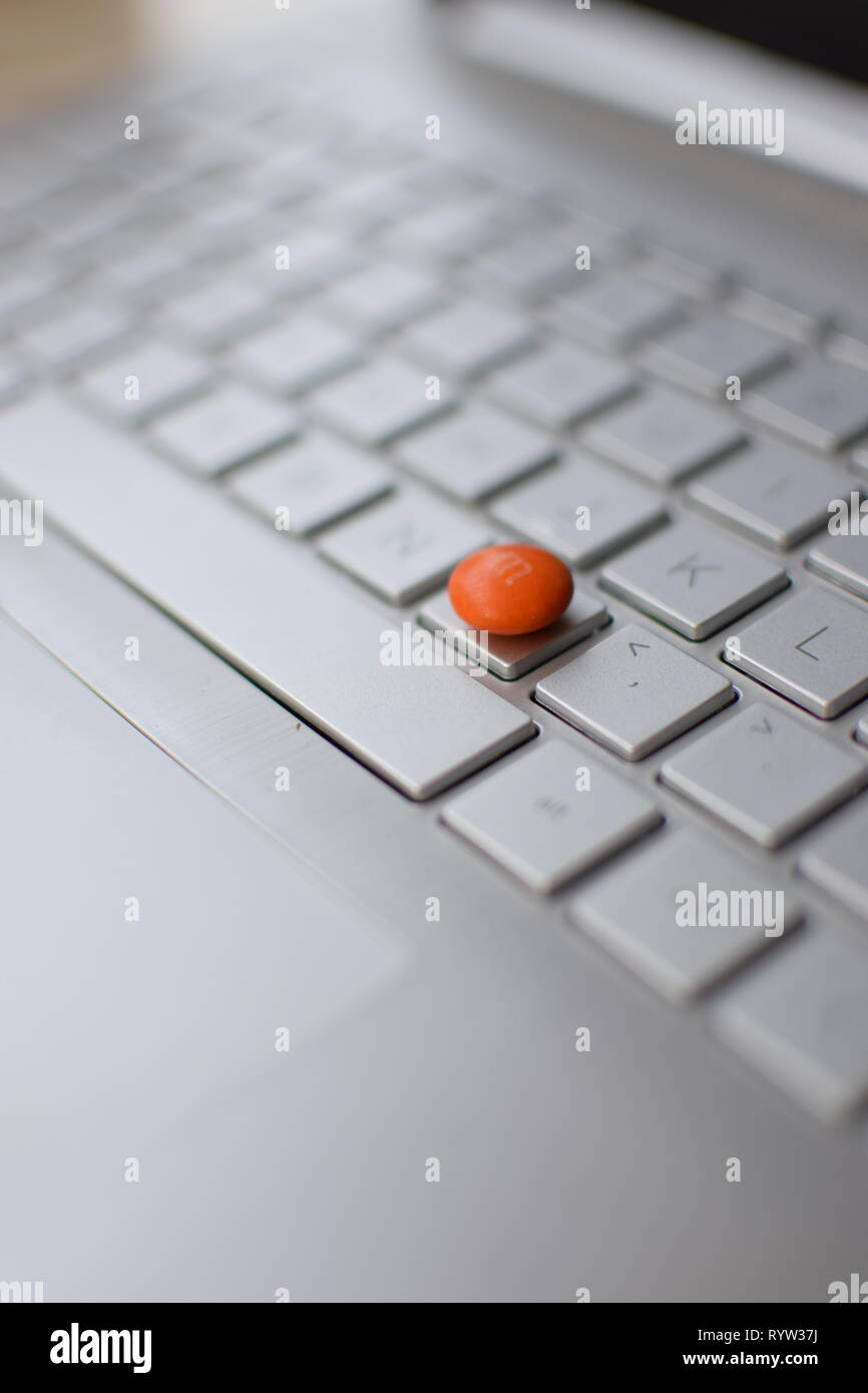 Computer (Laptop) Taste auf der Tastatur M austauschen (orange Edelsteine  Schokolade mit Buchstaben m oberhalb der Taste M Stockfotografie - Alamy