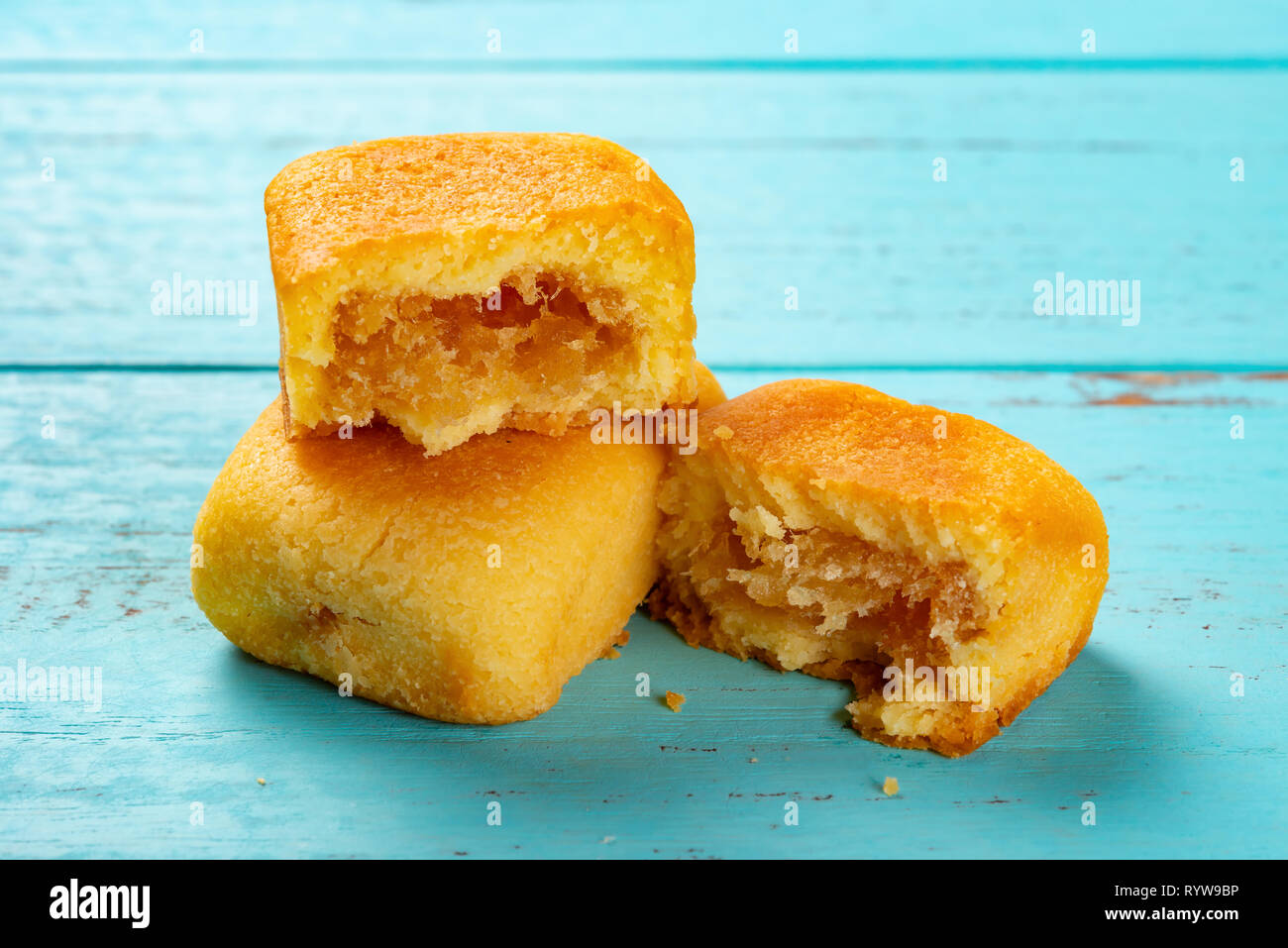 Seitenansicht Ananas Kuchen mit einem Schnitt auf blauem Hintergrund Stockfoto