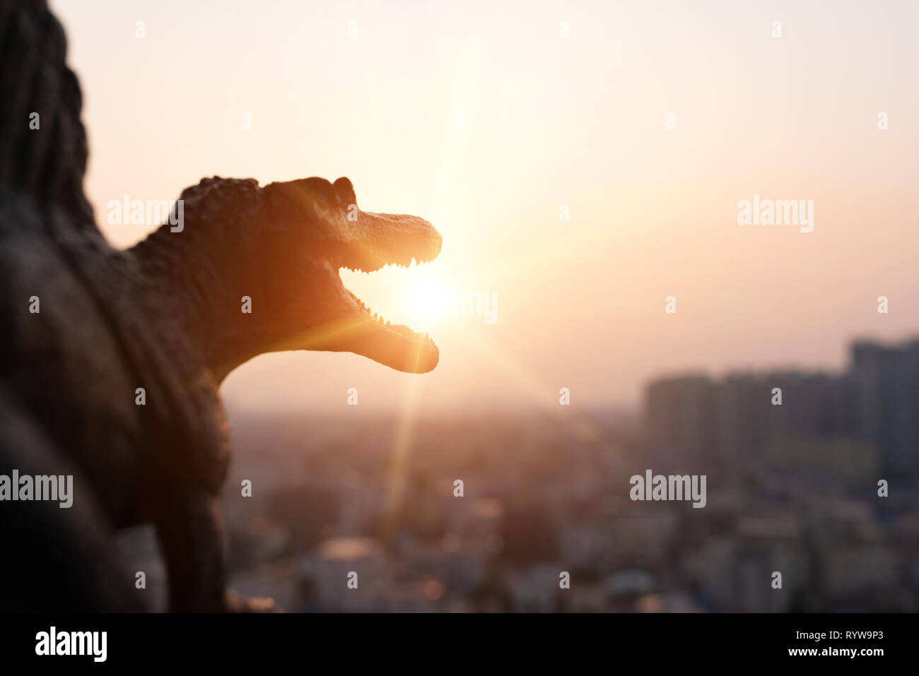 Silhouette von Spinosaurus und Gebäuden im Sonnenuntergang Stockfoto