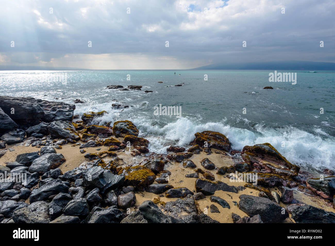 An der felsigen Küste - stürmische Wolken über einem felsigen Ufer an der Nord-westlichen Küste von West Maui, Molokai Insel im Hintergrund. Hawaii, USA. Stockfoto