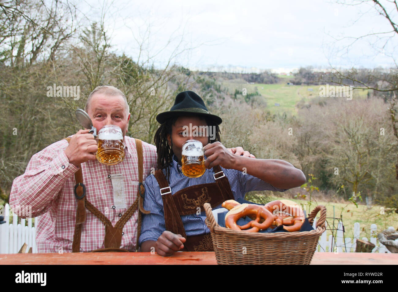Zwei Männer tragen bayerische Oktoberfest bemühen, trinken Bier und Gefühl glücklich im Freien Stockfoto