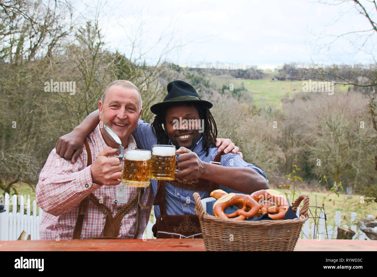 Zwei Männer tragen bayerische Oktoberfest bemühen, trinken Bier und Gefühl glücklich im Freien Stockfoto