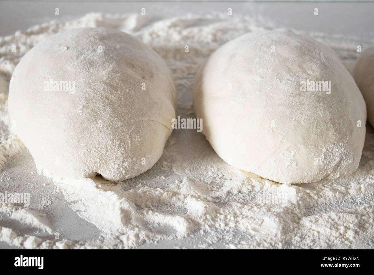 Teig Stücke liegen auf einem weißen Tisch mit Mehl. Stockfoto