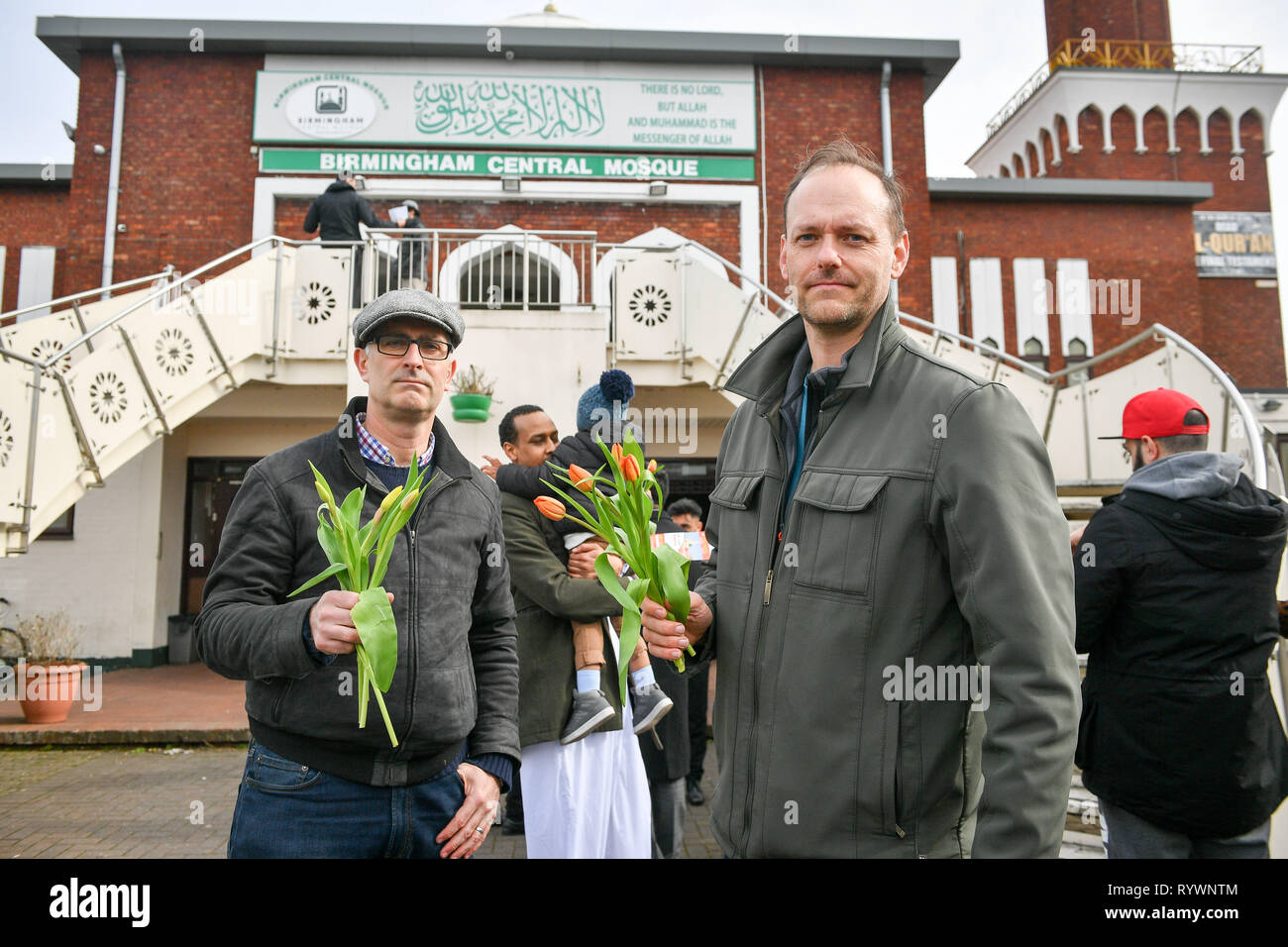 Christen James Lynch, Links, und Marcus Kapers vom Riverside Kirche, die Austeilen sind Blumen, die Muslime, wie sie Birmingham Central Moschee nach dem Anschlag auf die Moschee in Christchurch, Neuseeland verlassen. Stockfoto