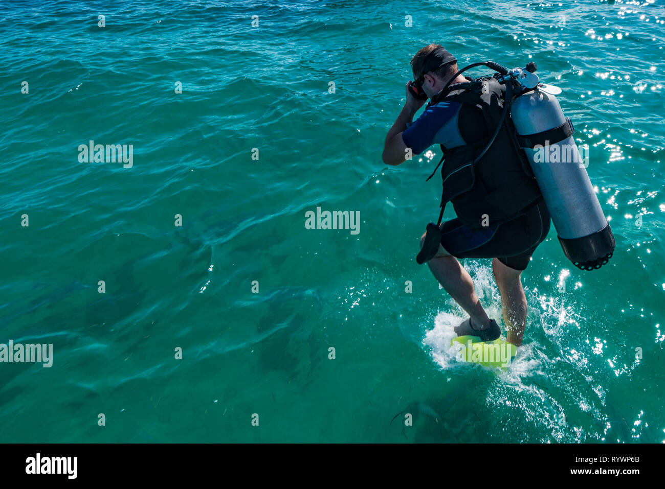Männliche Taucher mit Ausrüstung springt in Wasser Stockfoto