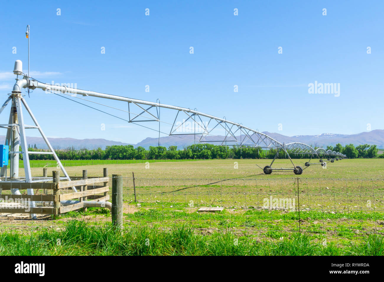 Große Drehmittelpunkt Bewässerungssystem läuft auf einem Bauernhof in Canterbury, Neuseeland. Lange bewegliche Booms der Wasserversorgung Anlagen erstrecken sich von f Stockfoto
