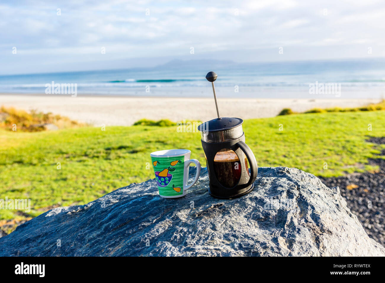 Kaffee Tasse und französischen Presse auf Felsen mit herrlichem Bayview, Northland Neuseeland Stockfoto