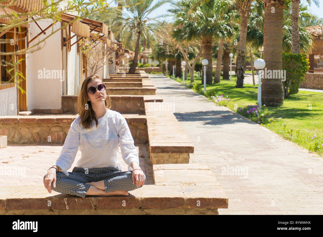Hübsche Frau, Meditieren über Resort im Urlaub Stockfoto