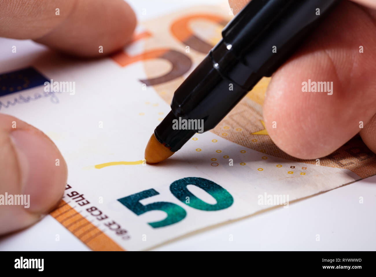 Nahaufnahme der Hand schreiben Auf Banknote mit gelben Marker Stockfoto