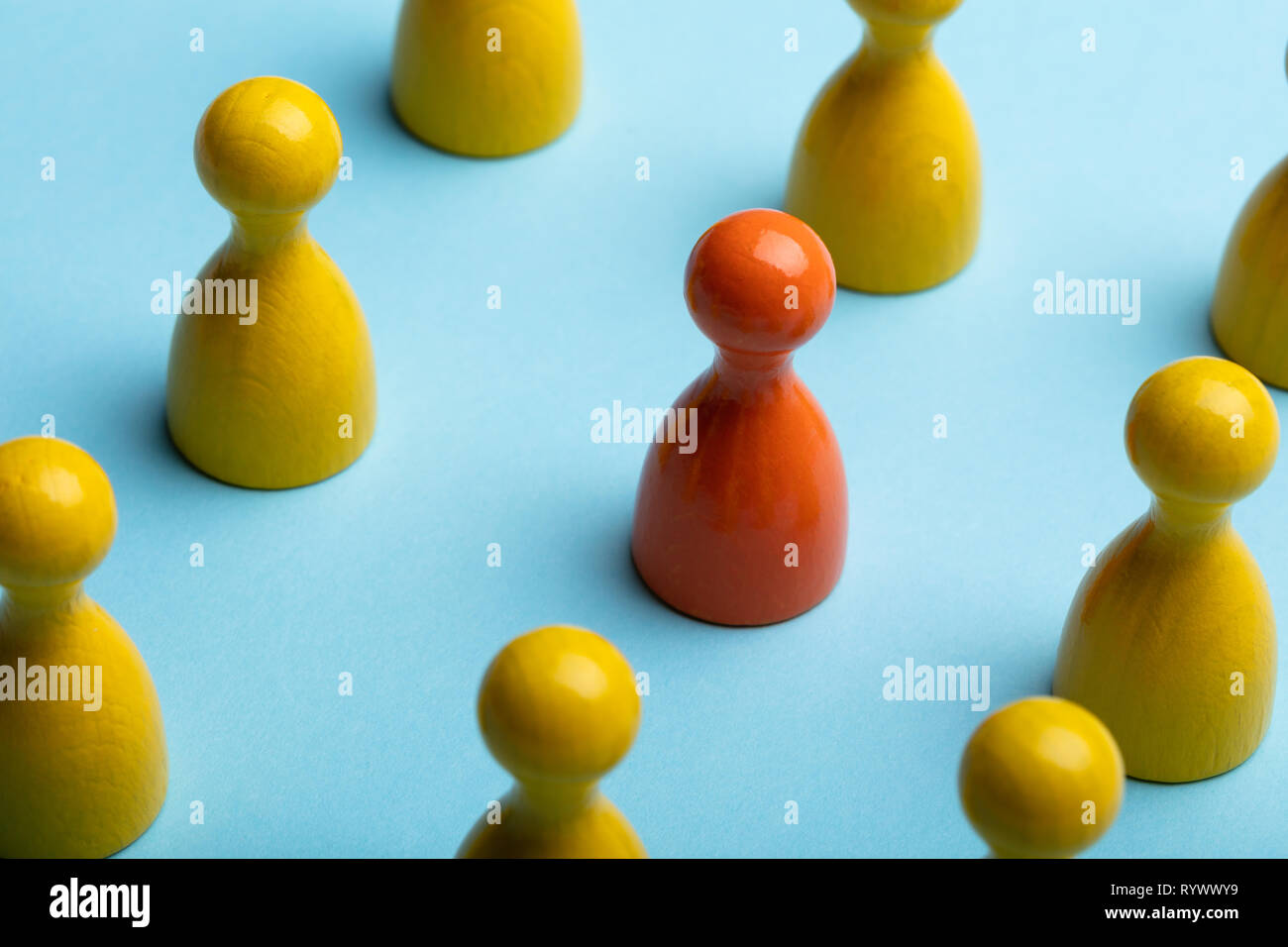 Rote und gelbe Spielfiguren Anordnen in einer Reihe über Blauer Hintergrund Stockfoto